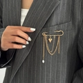 Dettaglio spilla a balia dorata vintage con ciondolo a cuore e nappe di perle su un blazer - Oro (0320)