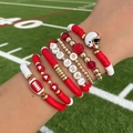 Detail of 7pcs stacked football charm bracelets with red heishi beads on a field - Red White Gold Sport Theme (6761)