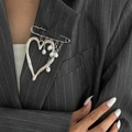 French lava heart brooch pin with white pearl tassels on a striped suit lapel - White K 0311
