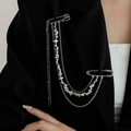 Macro detail of layered silver chain brooch with star charms on a black suit lapel - Silver With Silver Beads