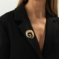 Spilla in metallo dorato irregolare appuntata sul risvolto di un blazer nero - 07 Oro 0331