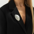 Spilla metallica irregolare argento con effetto specchio liscio su una giacca blazer nera - Ciottolo a Specchio (0334) / Argento