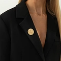 Spilla dorata irregolare con motivo a raggi di sole su un blazer nero elegante - Trama Solare a Spirale (0338) / Oro