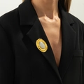 Spilla ovale irregolare oro e argento su un risvolto di una giacca blazer nera - Ovale Bicolore Oro Argento (0342) / Multicolore