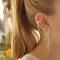 Close-up of silver metal leaf tassel ear cuff and stud set worn on ear - Triple Chain Tassel Style (EJ507)