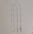 Detail of silver bead eyeglass chain showing metal links and clear silicone loop connectors - Silver