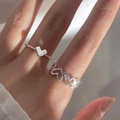 Bagues ouvertes argentées minimalistes au design de cœur, portées par un modèle - Combinaison de Bagues Cœur Superposables (1) / Argent