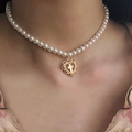 Vintage-Perlenkette mit goldenem Herz-Kreuz-Anhänger, getragen von einem Model - Weiße Perle Hohl Herz Kreuz Anhänger Stil (14)