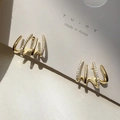 Detail of gold claw earrings with cubic zirconia pavé on minimalist 925 silver posts - Gold