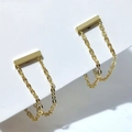 Detail von goldenen Kettenohrringen mit Stab-Design und minimalistisch drapierten Gliedern - Gold
