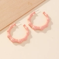 Detailed close-up of large pink bamboo-texture hoop earrings with a matte finish - Pink