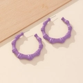 Close-up of purple bamboo-textured hoop earrings with a glossy metal finish - Purple