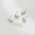 Detalle macro de pendientes de grano de café plateado con elegantes perlas blancas - Pendientes de Botón Grano de Café / Oro blanco