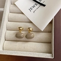 French vintage gold metal oval drop earrings with khaki enamel glaze on beige velvet display - Light Coffee