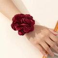 Detailed view of an elegant large burgundy satin rose wrist corsage with layered petals - Bracelet / Red