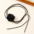 Detail of a black fabric rose choker featuring long cord and silky layered flower petals - Black