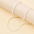 Minimalist white irregular beaded necklace with metallic lobster clasp on display - Stone White