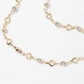 Macro detail of gold-toned necklace featuring hollow heart links and sparkling zircons - Golden Bracelet