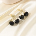 Boucles d'oreilles cerises dorées avec fruits noirs sur fond de tissu en soie blanche - Noir