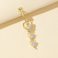 Piercing de ombligo con corazón dorado y circonitas sobre fondo de papel minimalista - Estilo Triple Corazón (7)