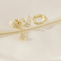 Macro shot of three gold mismatched earrings with zircons on soft beige silk background - Butterfly Flower Style - Gold (1)