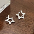 Minimalist silver pentagram hoop earrings with hollow star design on a dark wood surface - Minimalist Hollow Star Ear Clip (0983)