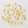 Set di anelli per capelli in metallo dorato e polsini per trecce su sfondo bianco - Oro