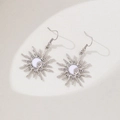 Close-up of silver sun earrings with moon and star enamel details and rhinestones - Silver Earrings