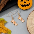Macro shot of orange and white striped candy earrings with festive pumpkin decoration - Orange and White Striped Candy Style (2)