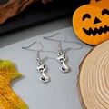 Close-up van vintage zilveren kattenoorbellen op een rustieke herfst Halloween-decor - Kattenstijl (18)