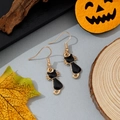 Détail de boucles d'oreilles chat en émail noir avec contours dorés sur fond d'automne - Style Silhouette de Chat Noir à Queue Courbée (13)