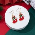 Festive red Christmas stocking drop earrings with holly leaf and white bow accents - Christmas Stocking Style (1)
