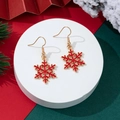 Detailed view of red and gold snowflake earrings on a festive Christmas display - Red Snowflake Style (4)