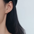 Aros en forma de C dorados minimalistas con pequeño cristal tipo botón en la modelo - 590 Dorado Diamante Único