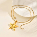 Vue détaillée d'un collier pendentif étoile de mer dorée sur surface blanche - 51cm / Or/Pendentif avec Chaîne
