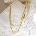 Dettaglio di una collana a due strati in oro con ciondolo a cuore e scritta love - Catena Piatta Doppio Cuore (UK03)