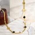 Dettaglio della collana a catena serpente dorata con ciondoli in smalto bianco e nero - Catena a Serpente Disco Nero Bianco (UK07)