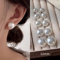 Elegante pendiente de perla blanca de 12mm mostrado en modelo y bandeja de joyería - US 12 / Blanco