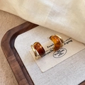 Detalle de pendientes C dorados vintage con resina de ámbar en tarjeta beige - Estilo de Doble Anillo en C / Pack de 1 par / Marrón dorado