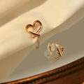 Polished gold heart-shaped clip-on earrings on silk fabric and vintage mirror background - Mosquito Coil Ear Clip / Rose Gold
