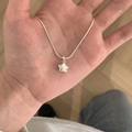 Elegant silver star pendant necklace with fine chain displayed on a hand - Sweet Little Star Style / Silver