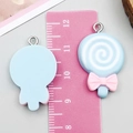 Macro d'un pendentif sucette en résine bleue de 4cm avec nœud rose et anneau métal - Bleu lac