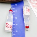 Close-up of resin ramune bottle charms with pink cherry blossom pattern and ruler - Small Bottle Style (24645) / Clear White