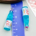 Detailed view of miniature blue resin soda bottle charm with silver metal hook - Small Bottle Style (24646) / Transparent Blue
