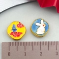 Detail shot of Chinese style enamel pendants with rabbit and pagoda designs measuring 12mm - Blue and Yellow Enamel Moon Rabbit (22652)