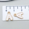 Detail of white enamel letter A charm showing 1.3cm size measurement on a scale - Letter A