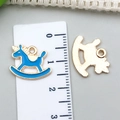 Detalle del dije de caballo balancín azul claro mostrando el frente y el revés de metal dorado - Caballo Balancín Esmalte Azul Lago 16x12mm (11956)