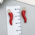 Macro shot of red enamel chili charms with gold loops next to a measuring ruler - 22x6mm Style (23372)