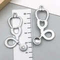 Detailed view of silver stethoscopes charms with white enamel and sparkling rhinestone inlay - White Stethoscope (23221)