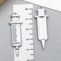 Detailed macro view of silver medical syringe pendants with centimeter ruler scale - White Syringe (23223)